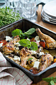 Oven-roasted chicken legs with olives, tomatoes and feta cheese