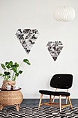 Chair, houseplant on side table and arrangement of black-and-white photos on wall