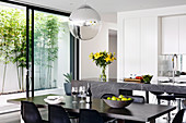 Dining table in front of the modern open kitchen with patio door