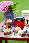 Two tone muffins garnished with redcurrants on a summer garden table