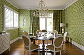 Dining room in shades of green with graphic pattern on wallpaper