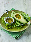 Avocado with vinaigrette dressing and chives ona bed of lettuce