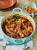 Slow cooked French cassoulet with sausages and beans in tomato sauce with bouquet garni