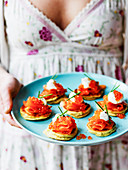 Easter lunch Smoked salmon and salmon caviar on blinis held in the hand