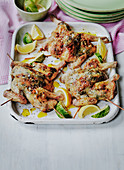 Grilled Spatchcock chickens with lemon and lime wedges