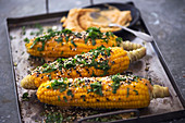 Corn cobs with herbs, sesame seeds and chilli served with mango butter