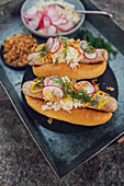 Hot Dogs mit Bratwurst, Kraut, Radieschen und Röstzwiebeln