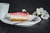 A slice of cheesecake with berries and a biscuit base