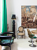 Black leather couch, table lamp on pillar, chair and painting in dining area with classic chairs