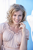 A blonde woman wearing a pink short-sleeved blouse