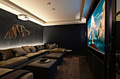 Chic home cinema in dark tones and extended sofa seating