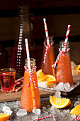 Aperol-Cocktails in Flaschen, Orangenschnitze und Eis