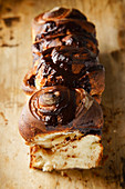 Swirl bread loaf with cocoa and chocolate sliced on white concrete background