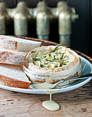 Baked camembert cheese, rosemary and thyme and white crusty bread