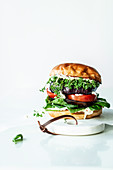 A veggie burger made with aubergines, tomatoes, spinach and cress
