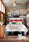 Dog is lying in front of the bed in a converted barn