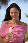 A young brunette woman wearing a red-and-white striped top holding a refreshing drink
