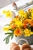 Blumentorte aus Ranunkeln, Osterglocken und Gerbera als Tischdekoration