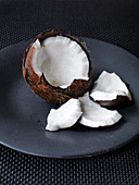 Opened coconut on black plate