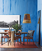 Dining table with leather chairs in the room with blue walls