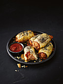 Sausages in puff pastry with cheese and ketchup (sausage rolls)