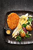 Chickpea schnitzel with asparagus, hollandaise sauce and potatoes