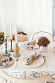 Herbstlich gedeckter Tisch mit Hortensienblüten und Kerzenständern