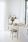 Table set for Easter breakfast in dining room decorated entirely in white