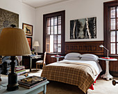 Kunstwerk über Doppelbett mit Vintage Kamelhaardecke im Schlafzimmer, originale Fensterläden, Beistelltische aus alten Straßenlaternen