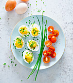Stuffed eggs with chives and cherry tomatoes