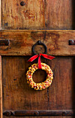 Small Christmas wreath with ribbon decorating door