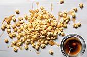 Ahornbutter-Popcorn beträufelt mit Ahornsirup (Aufsicht)
