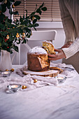 Woman slicing Panettone Christmas cake