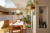 Dining table and chairs in open-plan kitchen with skylight