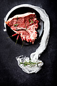 Raw beef steak with rosemary and chilli peppers