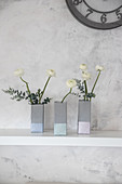 DIY-Vasen im Beton-Look aus Milchtüten mit Ranunkel auf Ablage