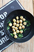 Mini potato dumplings with roast onions in a pan