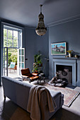 Sofa in front of open fireplace in classic grey living room