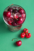 Kirschen und Eiswürfel in einem Glas