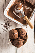 Scoops of chocolate ice cream with chocolate sprinkles in a cup