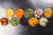Rows of various ingredients for power bowls in glass bowls (seen from above)