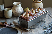 A loaf cake with pears in a baking tin