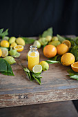 Freshly pressed orange juice and fresh citrus fruits on a rustic wooden table