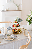 Berries and madeleines on cake stand on table festively set for afternoon coffee