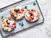 Cheesy, toasted vegetarian pizza bagels topped with fresh basil