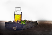 Basilikumöl mit Knoblauch auf rustikalem Holzbrett