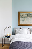 Winterliches Landschaftsbild an blauer Wand überm Bett
