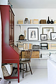 Red bureau next to shelves decorated with ornaments in natural shades