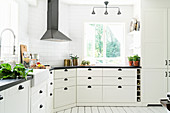 Light-flooded country-house kitchen decorated in white