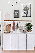 Row of hooks above vintage accessories on white sideboard